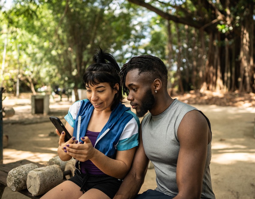 Couple outdoors looking at a phone