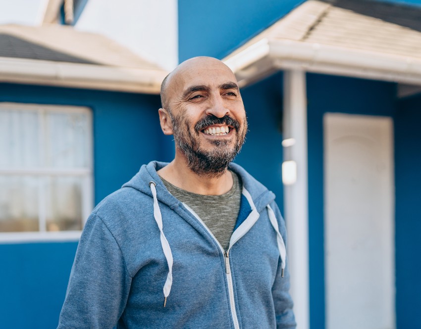 Man in front of blue house